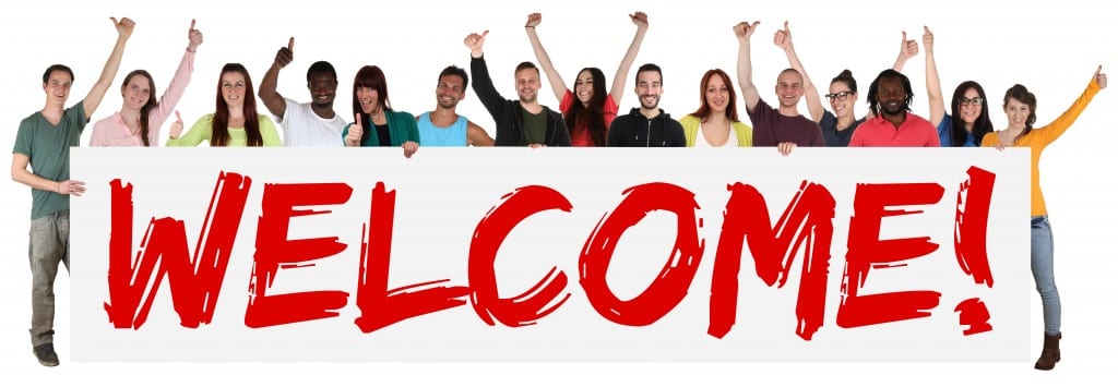 Welcome sign group of young multi ethnic people holding banner isolated